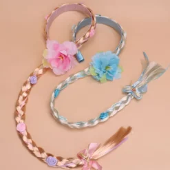 Prinsesseparyk med lange fletninger og hårbånd, med blå blomster og hvide fletninger.