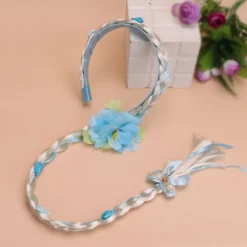 Prinsesseparyk med lange fletninger og hårbånd, med blå blomster og hvide fletninger.